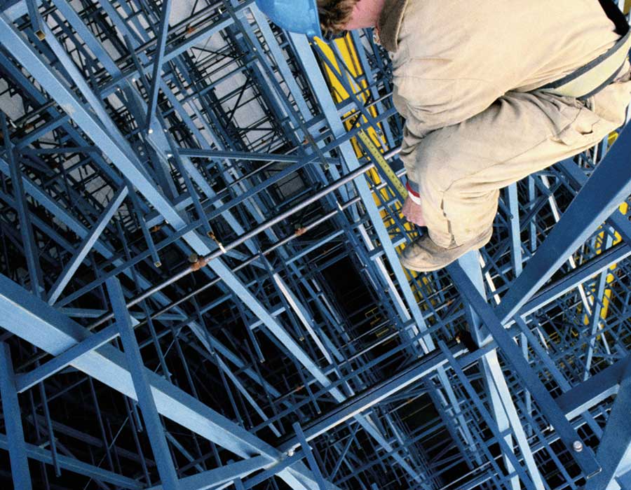 Worker secured by safety ropes while navigating a framework structure